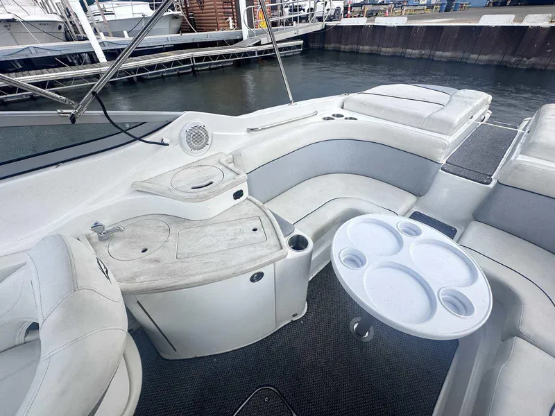 Slide: The Image of 2015 Rinker 276 Captiva Bowrider interior with seating and table, docked at marina. - 15