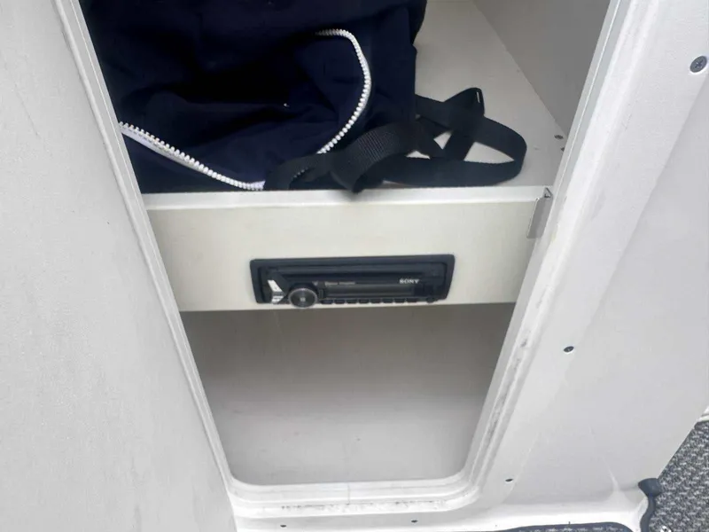 Slide: The Image of 2015 Rinker 276 Captiva Bowrider storage compartment with a Sony stereo system. - 28