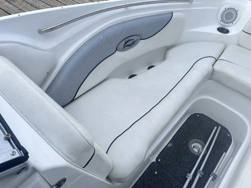 Slide: The Image of 2015 Rinker 276 Captiva Bowrider interior seating with white upholstery and storage compartment. - 33