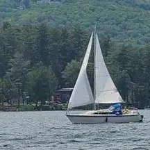 The Image of 1987 O'Day 272 sailboat on a lake with forested hills in the background. - 0