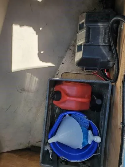 Slide: The Image of Storage compartment with fuel can, funnel, and battery in 1987 O'Day 272 sailboat. - 17