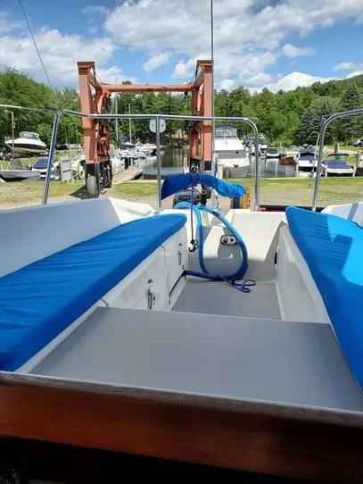 Slide: The Image of 1987 O'Day 272 sailboat cockpit with blue cushions, docked under a clear sky. - 21