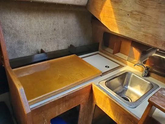 Slide: The Image of 1987 O'Day 272 sailboat interior galley with wooden cabinetry and stainless steel sink. - 24