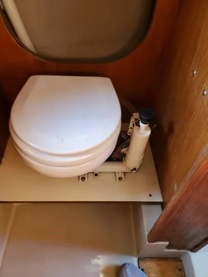 Slide: The Image of 1987 O'Day 272 marine toilet in compact wooden bathroom setting. - 28