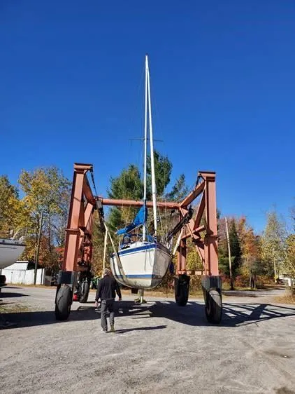Slide: The Image of 1987 O'Day 272 sailboat on a lift, surrounded by autumn trees under a clear blue sky. - 7