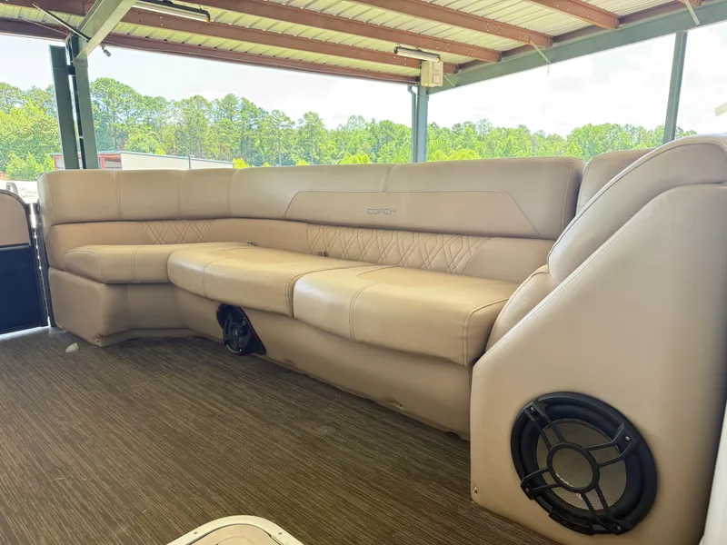 Slide: The Image of Luxurious seating on 2016 Coach Pontoons 25RF, featuring beige upholstery and built-in speakers. - 13