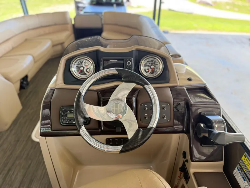 Slide: The Image of 2016 Coach Pontoons 25RF helm with steering wheel and dashboard controls. - 7