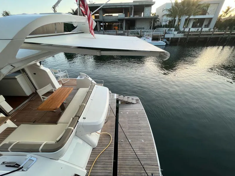 Slide: The Image of Luxury Schaefer 510 yacht, 2019 model, docked by waterfront with elegant seating area. - 39