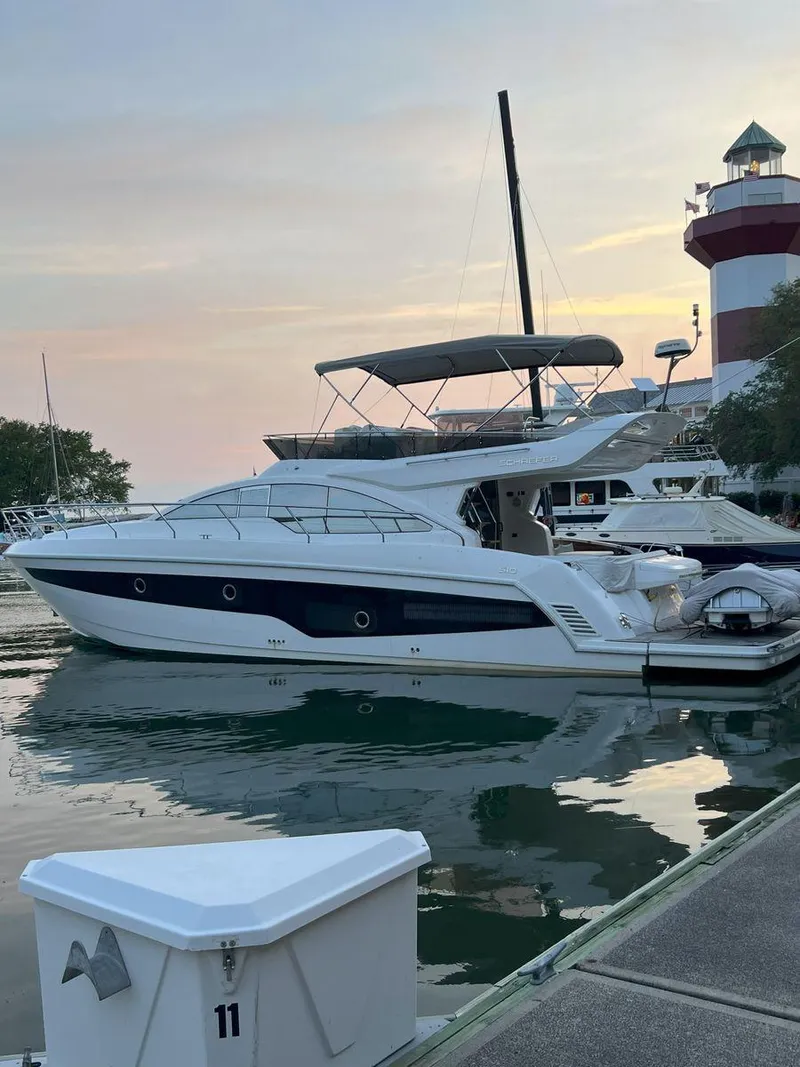 Slide: The Image of 2019 Schaefer 510 yacht docked near a lighthouse at sunset. - 4