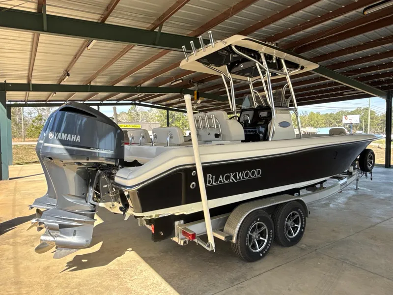 The Image of 2013 Blackwood 27 boat with Yamaha engine on a trailer in a covered area. - 1