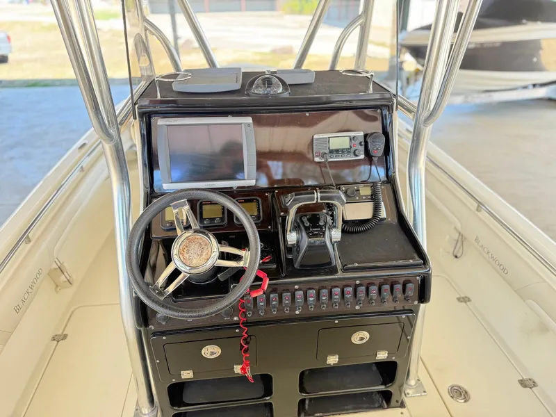 Slide: The Image of 2013 Blackwood 27 boat console with steering wheel, controls, and navigation equipment. - 10