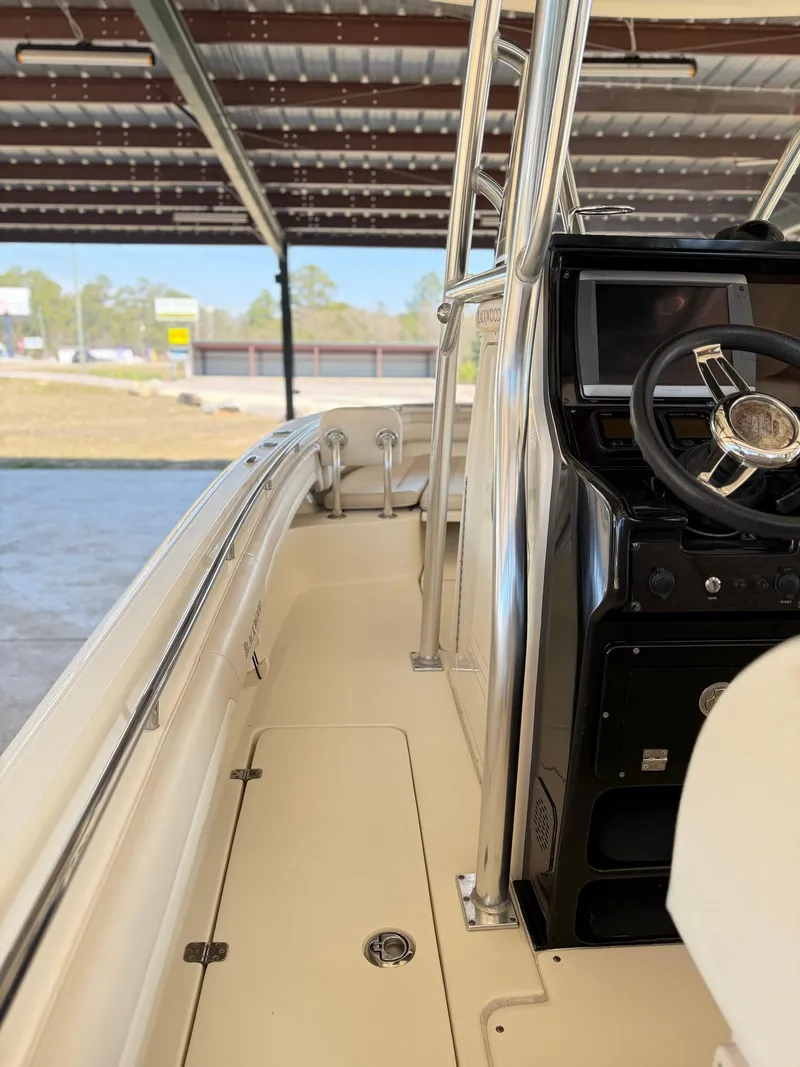 Slide: The Image of 2013 Blackwood 27 boat interior with steering wheel and console under a covered area. - 15