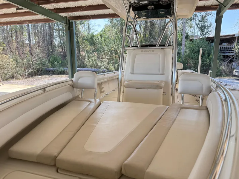 Slide: The Image of 2013 Blackwood 27 boat interior with beige seating under a covered area. - 18