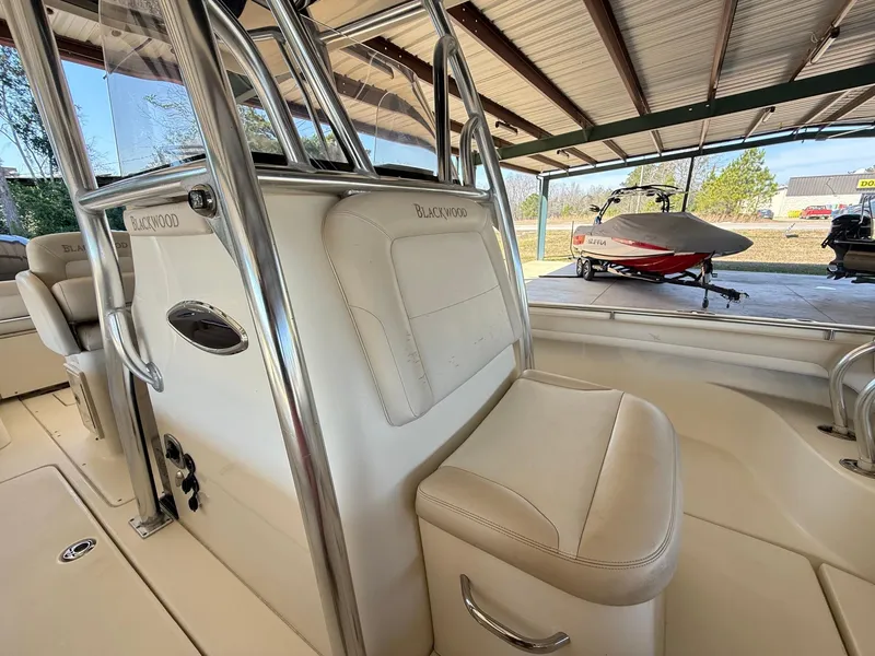 Slide: The Image of 2013 Blackwood 27 boat interior with seating and metal railings under a covered area. - 19