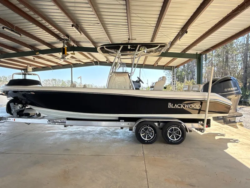 Slide: The Image of 2013 Blackwood 27 boat on trailer under metal roof, featuring Yamaha outboard motor. - 5