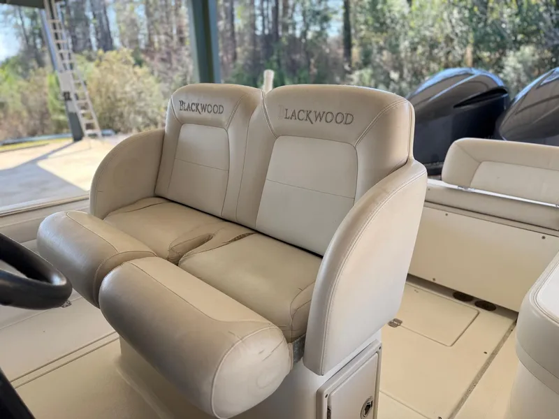 Slide: The Image of Luxurious seating on a 2013 Blackwood 27 boat, featuring comfortable beige upholstery. - 8
