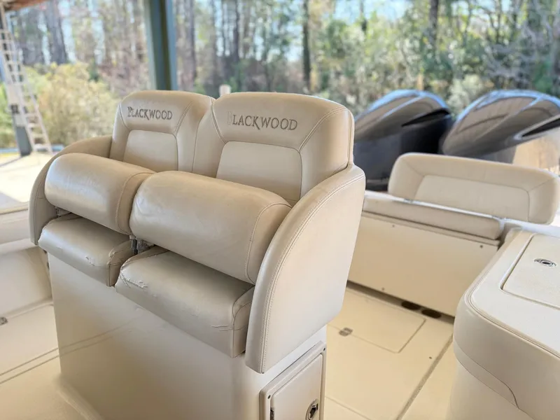 Slide: The Image of Luxurious seating on a 2013 Blackwood 27 boat, featuring dual engines in a serene outdoor setting. - 9