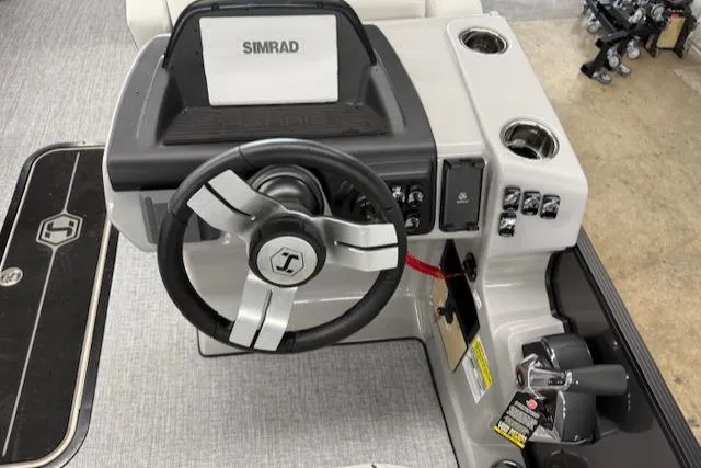 Slide: The Image of 2025 Harris Sunliner 230 boat dashboard with steering wheel and Simrad display. - 17
