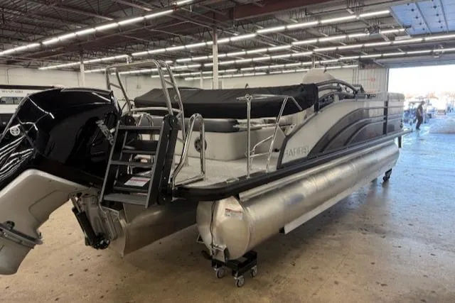 Slide: The Image of 2025 Harris Sunliner 230 pontoon boat in a warehouse, featuring sleek design and modern amenities. - 6