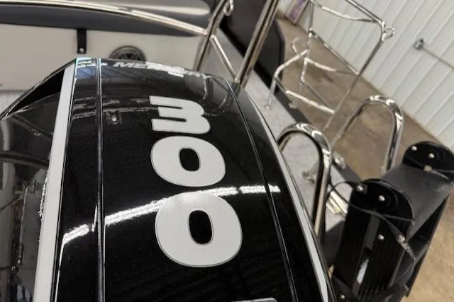 Slide: The Image of 2025 Harris Sunliner 230 boat with a 300 horsepower engine, docked indoors. - 8