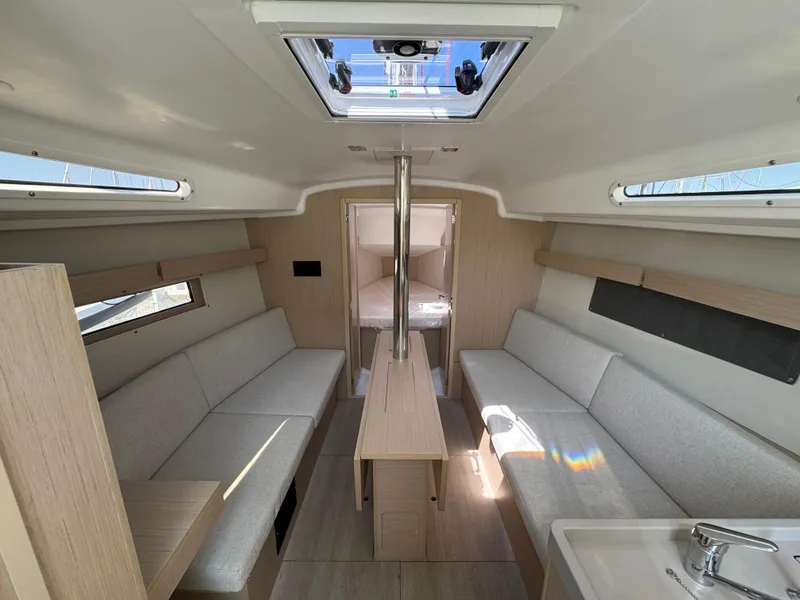 Slide: The Image of 2024 Beneteau Oceanis 34.1 interior, featuring modern seating and natural light. - 17