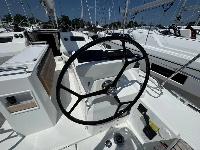 Slide: The Image of 2024 Beneteau Oceanis 34.1 yacht cockpit with steering wheel and navigation controls. - 4
