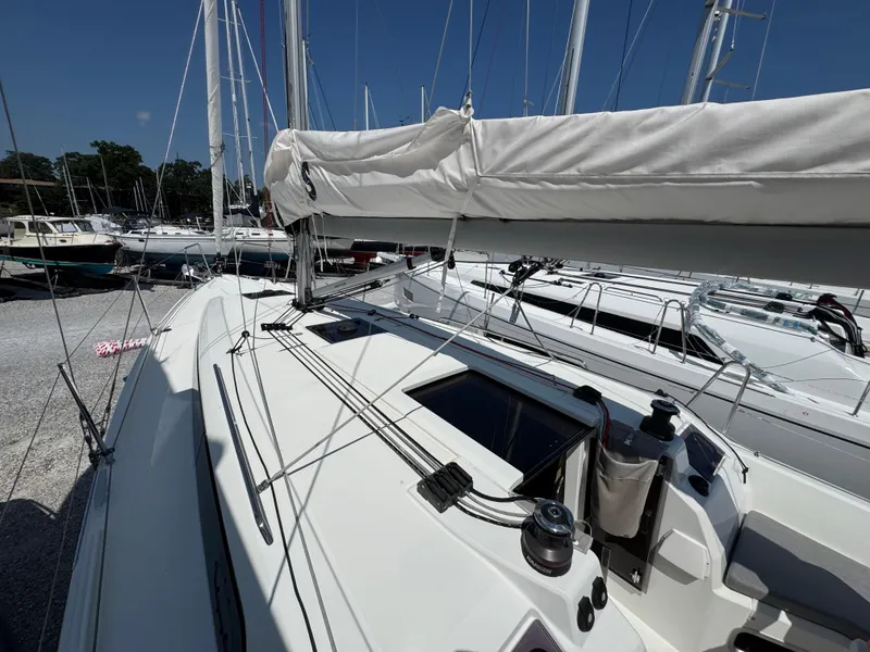 Slide: The Image of 2024 Beneteau Oceanis 34.1 sailboat deck with rigging and winches in marina. - 6