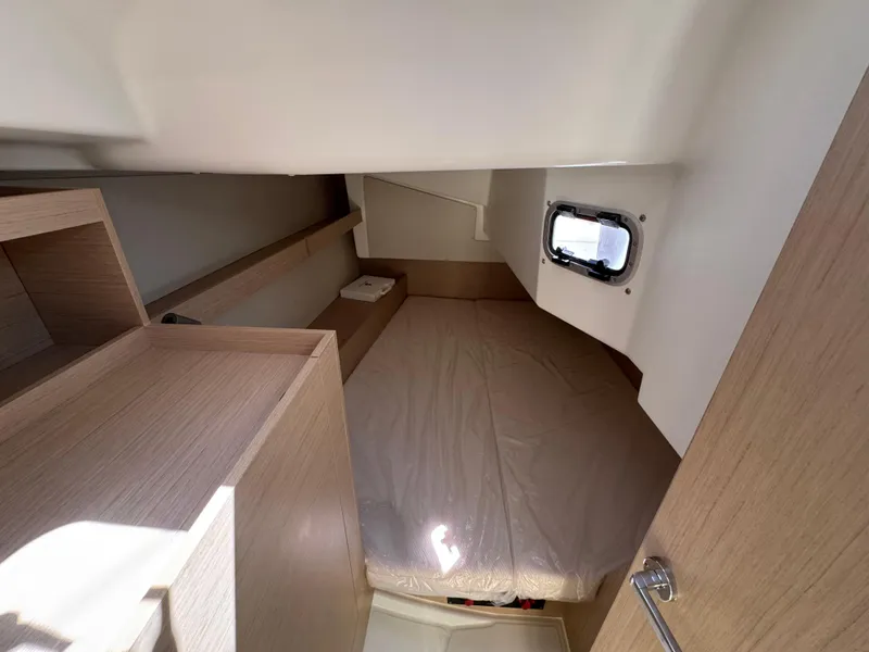 Slide: The Image of 2024 Beneteau Oceanis 34.1 cabin interior with bed and window, featuring light wood finish. - 9