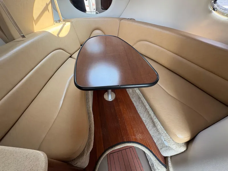Slide: The Image of 2019 Crownline 264 CR cabin interior with beige seating and wooden table. - 12