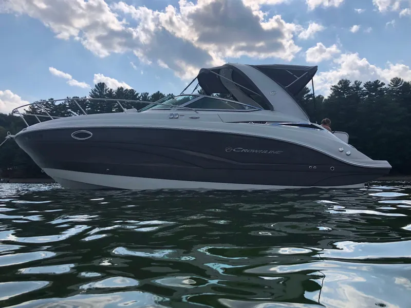 Slide: The Image of 2019 Crownline 264 CR boat on calm water under a partly cloudy sky. - 5