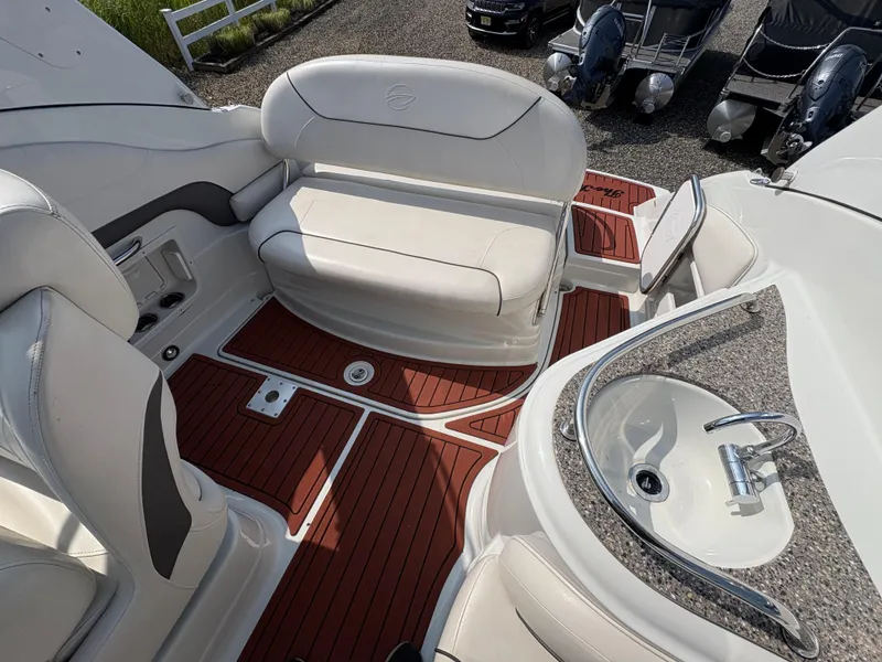 Slide: The Image of 2019 Crownline 264 CR boat interior with seating and sink, featuring elegant wood flooring. - 7