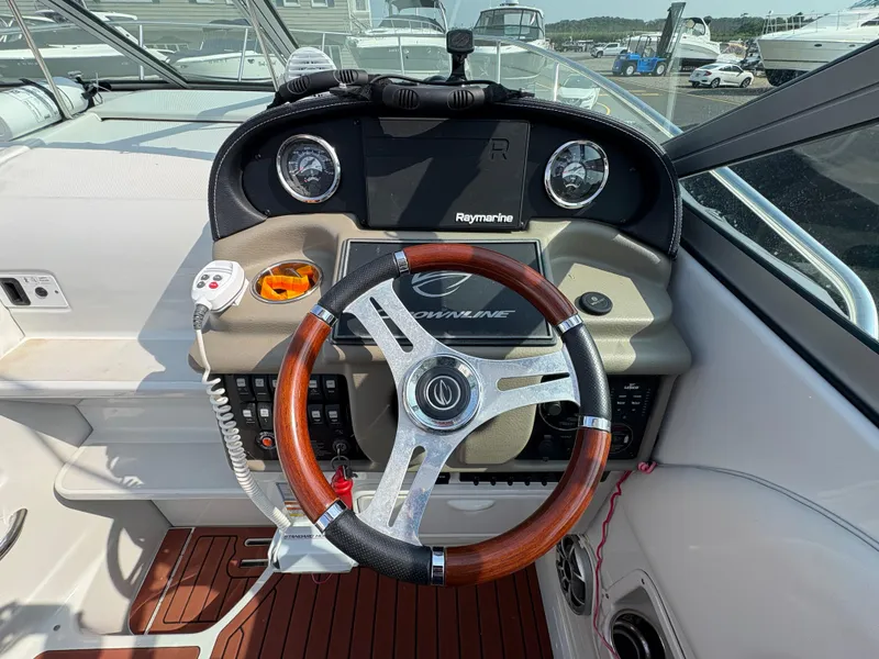 Slide: The Image of Steering wheel and dashboard of 2019 Crownline 264 CR boat, featuring Raymarine electronics. - 9