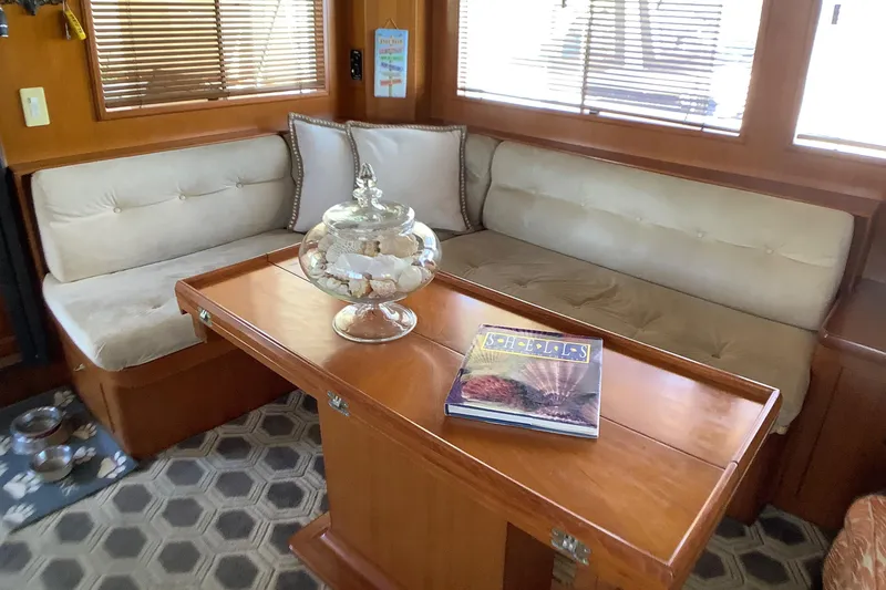 Slide: The Image of Cozy interior of 1998 Grand Alaskan 60 Pilothouse with cushioned seating and wooden table. - 12