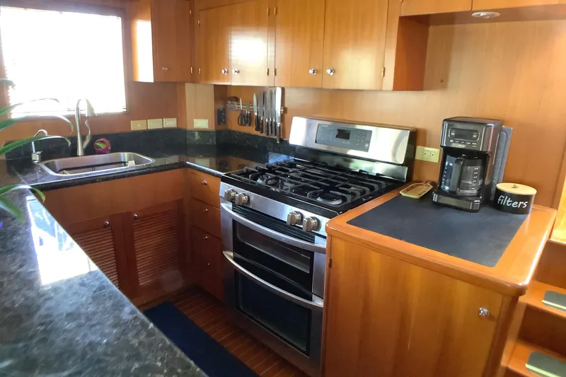 Slide: The Image of Kitchen area of 1998 Grand Alaskan 60 Pilothouse with stove, sink, and coffee maker. - 18