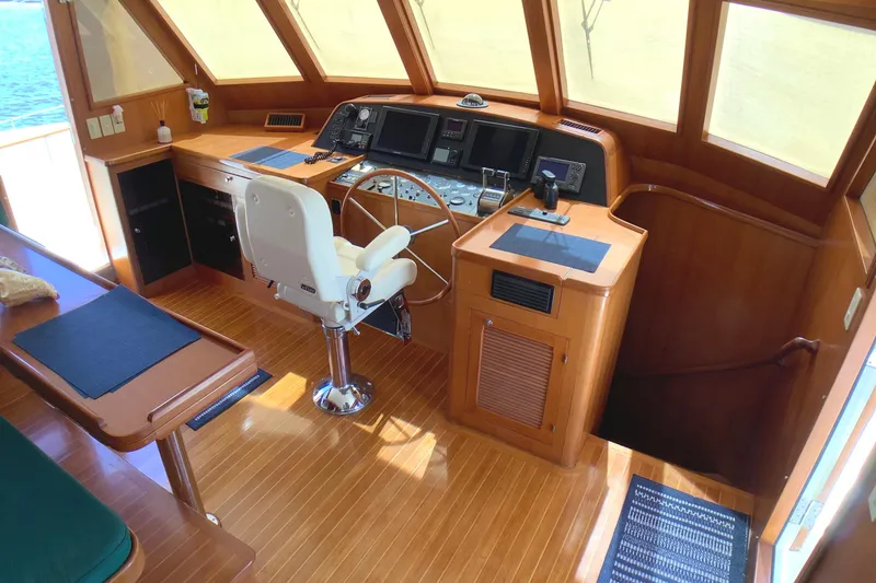 Slide: The Image of Pilothouse interior of 1998 Grand Alaskan 60, featuring helm station and wooden flooring. - 22