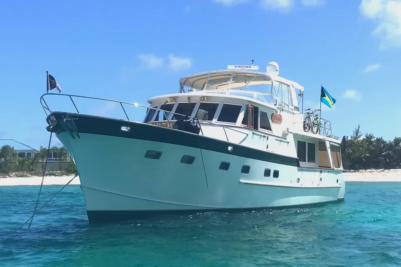 Slide: The Image of Grand Alaskan 60 Pilothouse yacht, 1998 model, anchored near a tropical beach. - 3