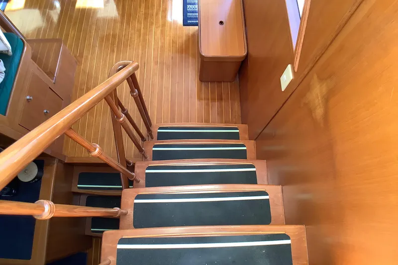 Slide: The Image of Wooden staircase inside 1998 Grand Alaskan 60 Pilothouse yacht, featuring non-slip treads. - 30