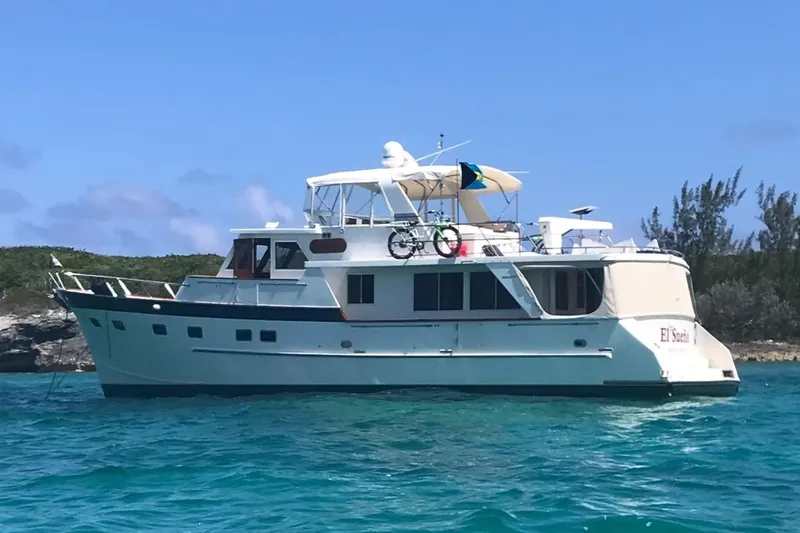 Slide: The Image of Grand Alaskan 60 Pilothouse yacht, 1998 model, anchored in clear blue waters. - 5