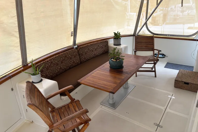 Slide: The Image of Spacious deck of 1998 Grand Alaskan 60 Pilothouse with wooden furniture and potted plants. - 7