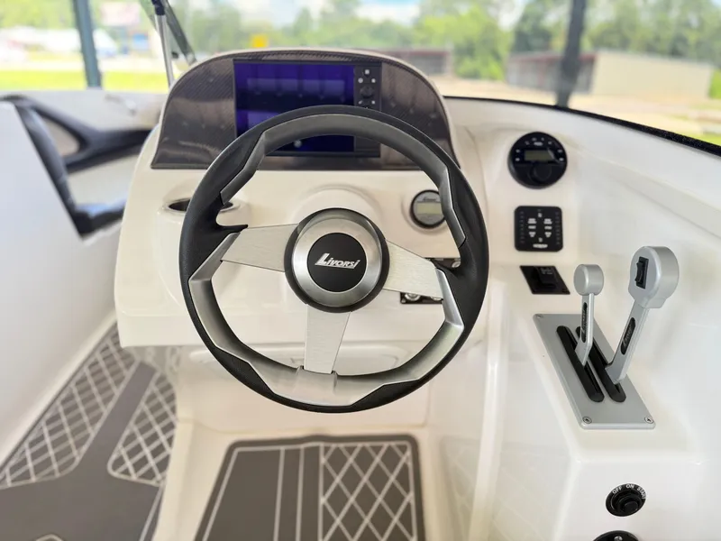 Slide: The Image of 2024 Checkmate Pulsare 2400 BRX boat cockpit with steering wheel and controls. - 12