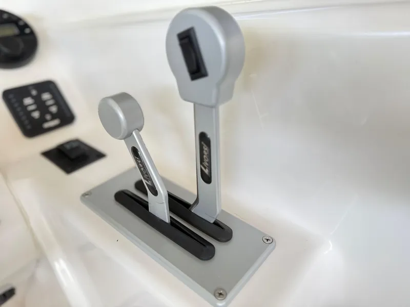 Slide: The Image of Throttle controls on 2024 Checkmate Pulsare 2400 BRX boat dashboard. - 15