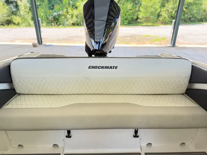 Slide: The Image of 2024 Checkmate Pulsare 2400 BRX boat interior with quilted seating and outboard motor. - 23