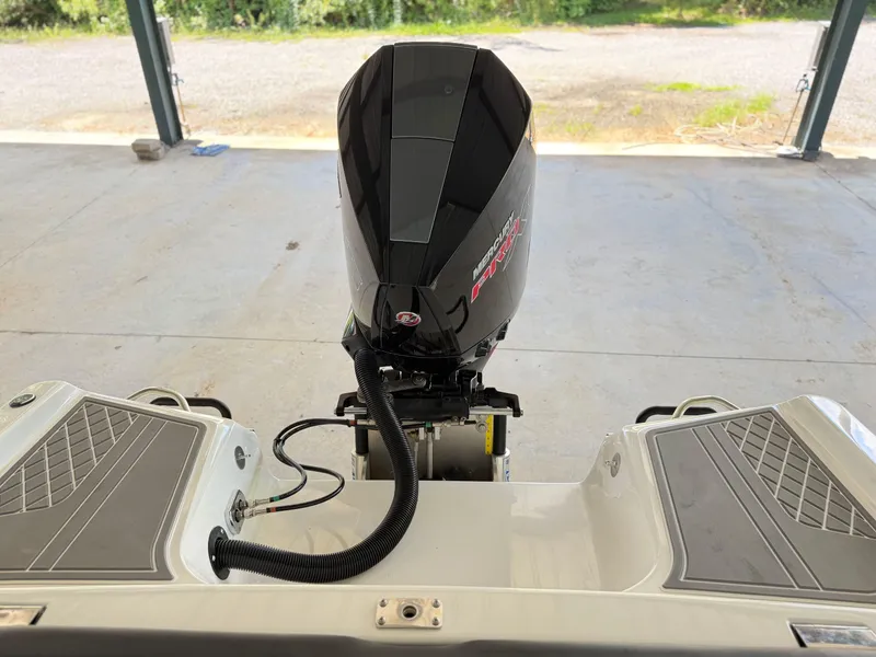 Slide: The Image of 2024 Checkmate Pulsare 2400 BRX boat with Mercury engine in a garage setting. - 25