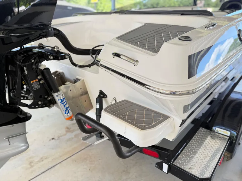 Slide: The Image of 2024 Checkmate Pulsare 2400 BRX boat rear view, showcasing motor and swim platform. - 27