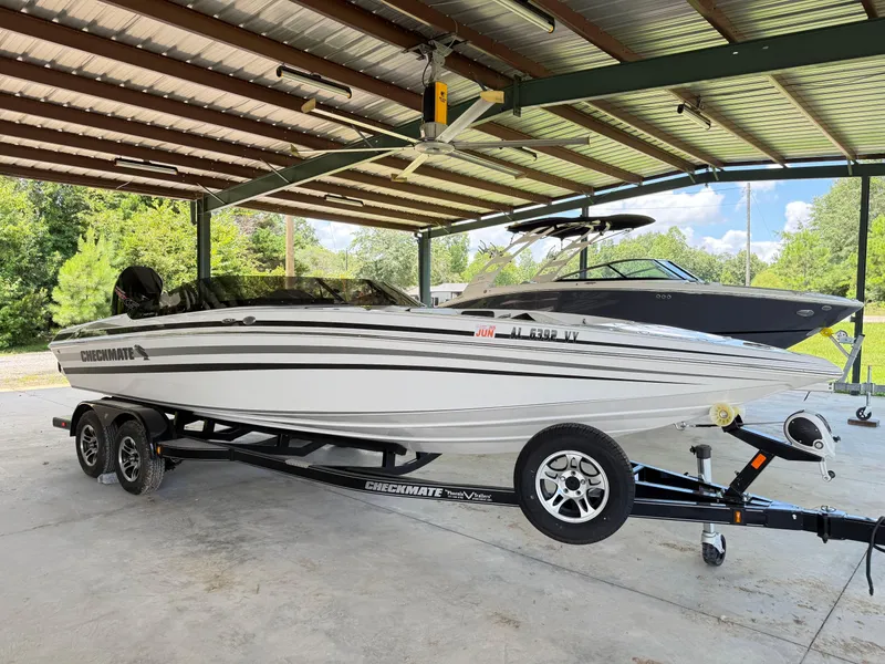 Slide: The Image of 2024 Checkmate Pulsare 2400 BRX boat on trailer under metal canopy. - 5