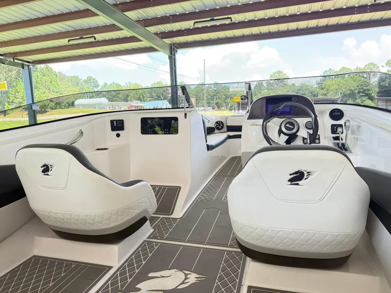 Slide: The Image of 2024 Checkmate Pulsare 2400 BRX boat interior with white seating and modern dashboard. - 9