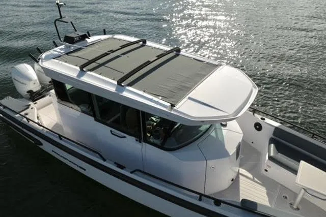 Slide: The Image of 2023 Axopar 28 CABIN boat on water, featuring sleek design and modern cabin. - 10