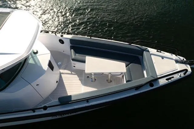 Slide: The Image of 2023 Axopar 28 CABIN boat with spacious seating and table on deck. - 2