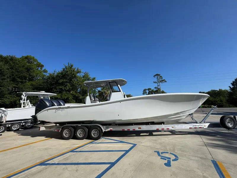Slide: The Image of 2026 Yellowfin 36 Offshore boat on trailer, parked in sunny outdoor setting. - 11