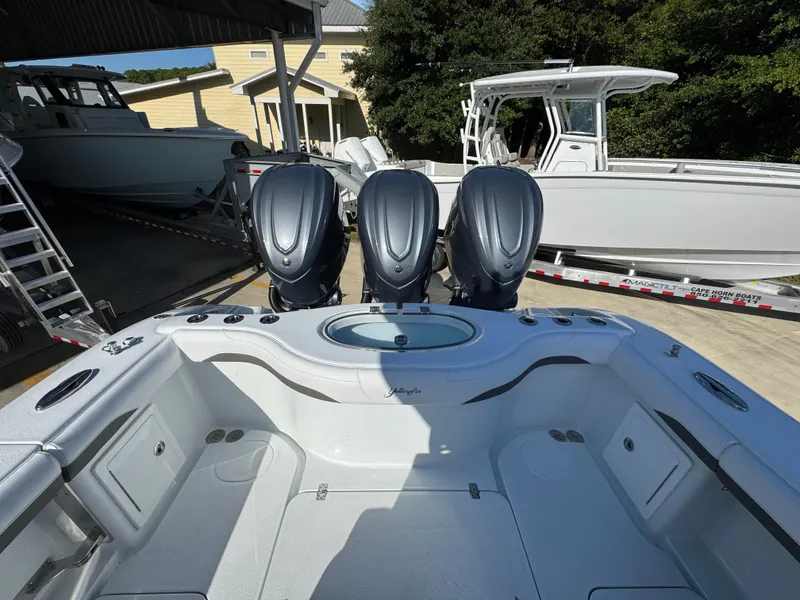 Slide: The Image of 2026 Yellowfin 36 Offshore boat with triple outboard engines, docked under a shelter. - 43
